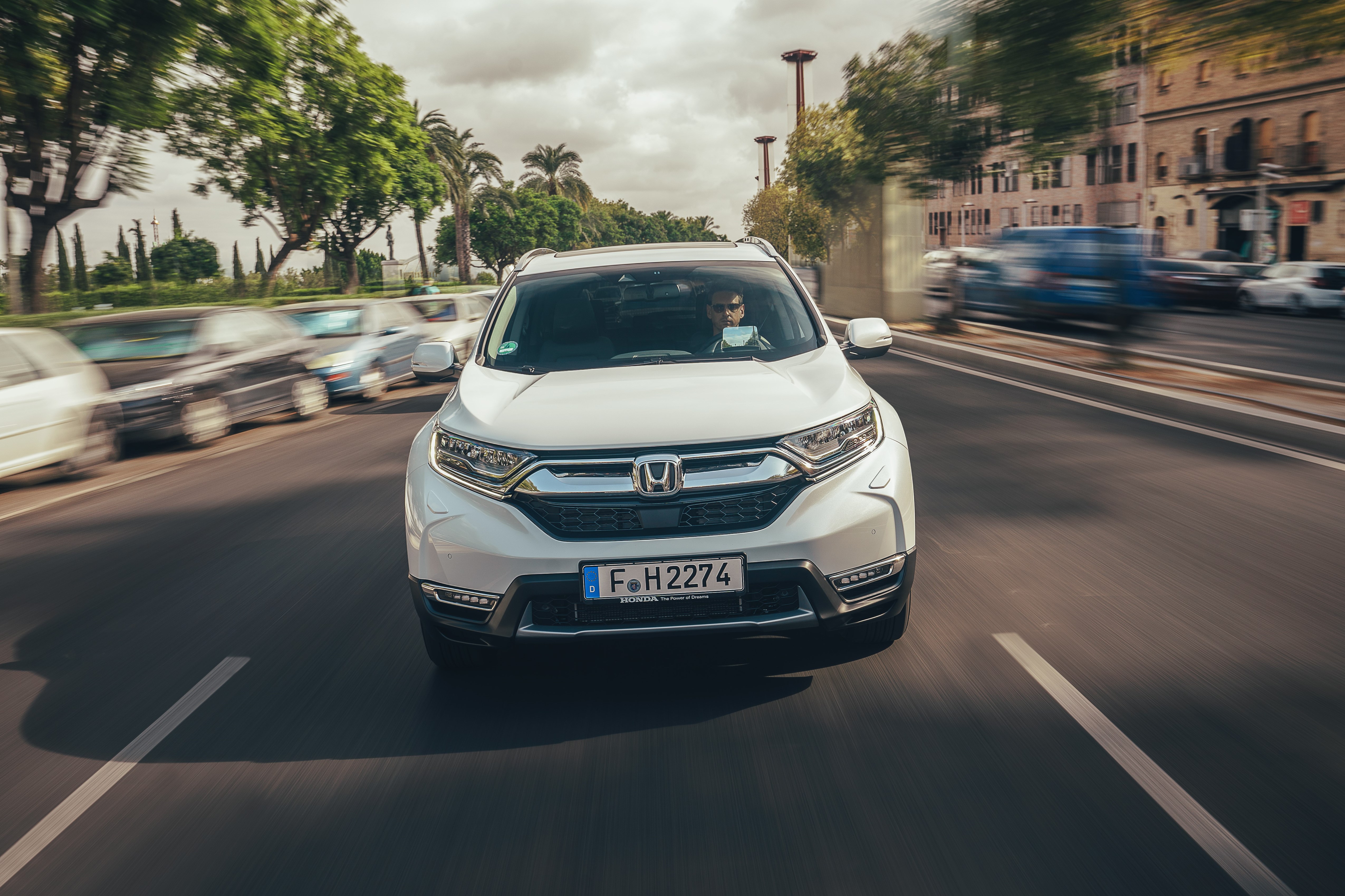 Frontale di Honda CR-V Hybrid bianca con uomo al volante